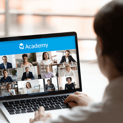 Back view of a man attending a QBE Q Academy virtual online training course on his laptop